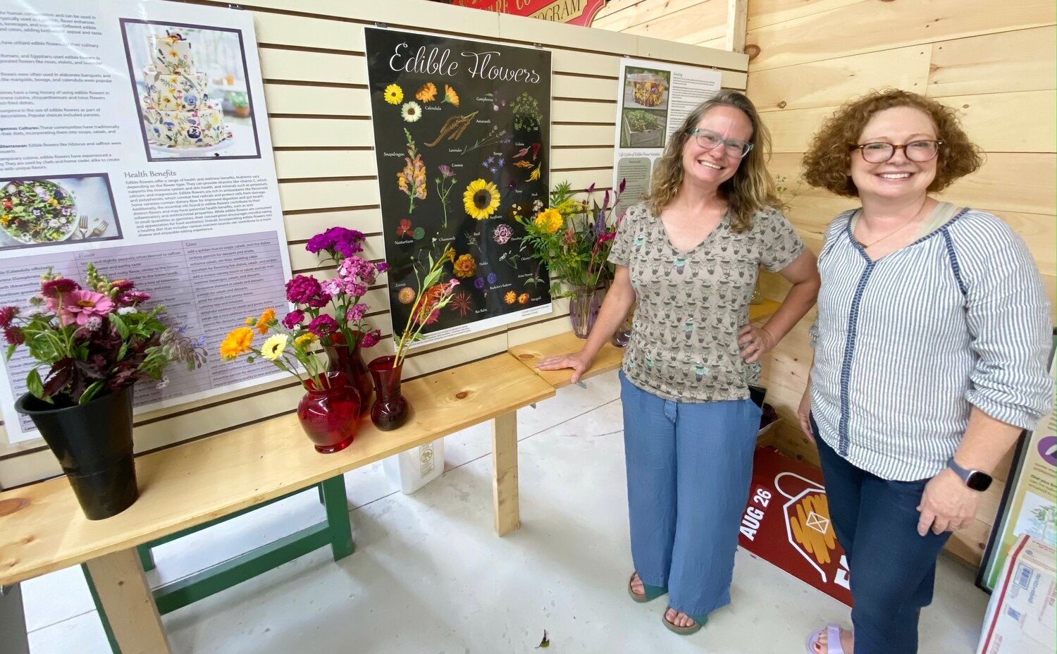 Carla Hegeman Crim and Rose Lees, master gardeners, hang an edible flowers display in the Cornell Cooperative Extension building, at the Delaware County Fair, Sunday, Aug. 13.